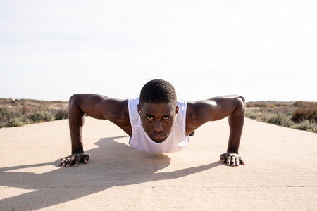 Young black runner doing push-ups.の写真素材