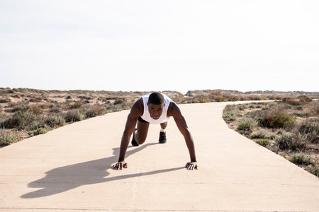 Young black runner doing push-ups.の写真素材
