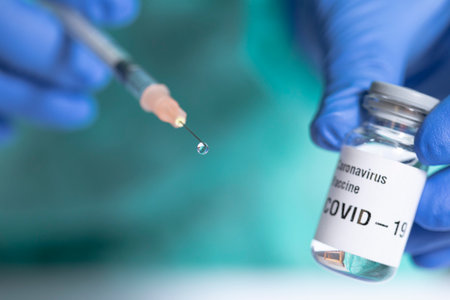 Close up of syringe with a vaccine drop. Focus on drop.の写真素材