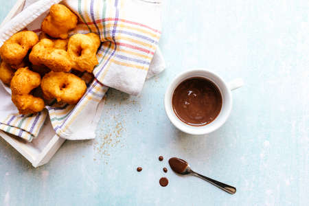 Flat lay of sweet fritters and a cup of chocolate.の写真素材