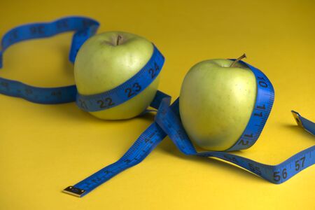 Diet concept, green apple with tape measureの写真素材