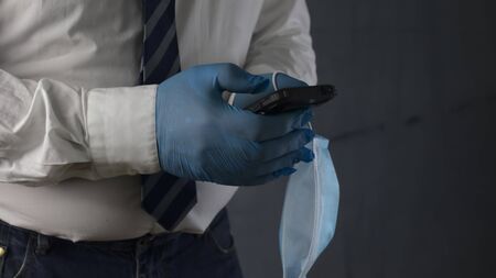 Businessman with protective mask using phone. Virus pandemic or epidemic concept.