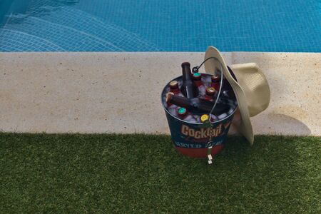 beer bottles in a bucket with ice by the poolの写真素材
