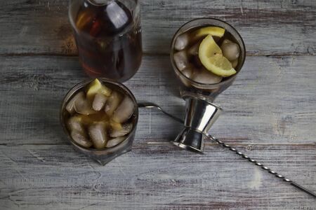 Refreshing Cuba Libre, made with aged golden rum, cola and lemon, prepared at home, after-dinner...