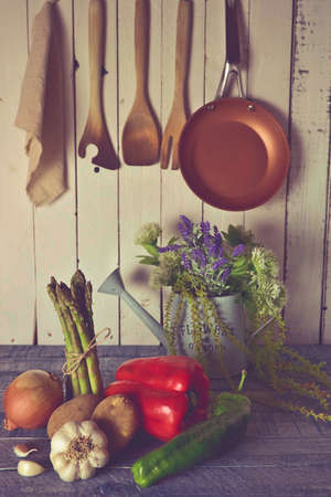 vegetables in a rustic kitchen with white board walls and aged blue countertopの写真素材