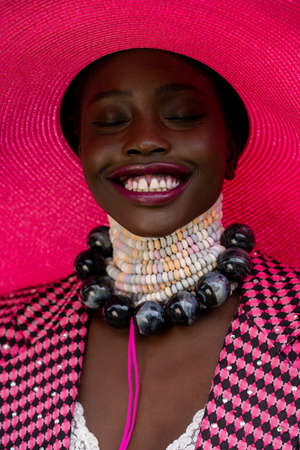 Beautiful African model with black skin and happy authentic smile. Vibrant colors, candy necklace,...