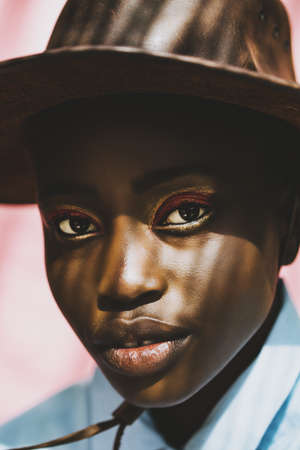Portrait of a black model against a pink background.の写真素材
