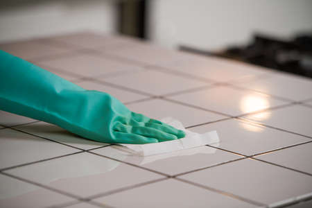 Disinfecting surfaces from bacteria or Covid-19, hand with glove cleaning kitchen surface with disinfectant wet wipe.の写真素材