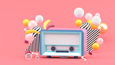 Blue radio amidst colorful balls on a pink background.-3d render.の写真素材