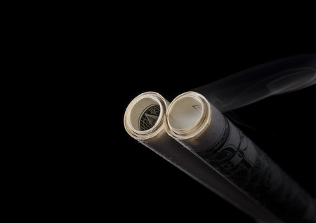 Smoking barrels made of dollars banknotes on isolated background