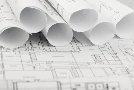 rolls of architecture blueprints and house plans on the table