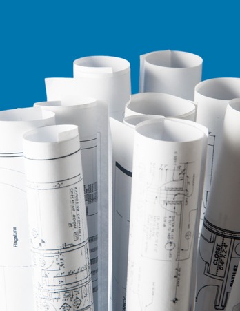rolls of architecture blueprints and house plans on the tableの写真素材