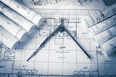 rolls of architecture blueprints and house plans on the table and drawing compassの写真素材