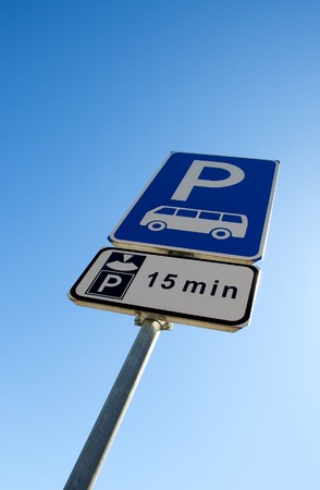 bus parking and limit time, blue and white road  signs on blue sky backgroundの写真素材