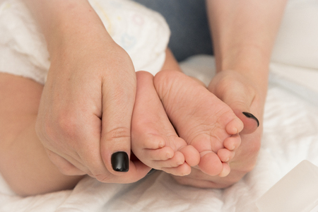 Baby feet in mother hands. Mom and her Child. Happy Family concept. Beautiful conceptual image of Maternityの写真素材