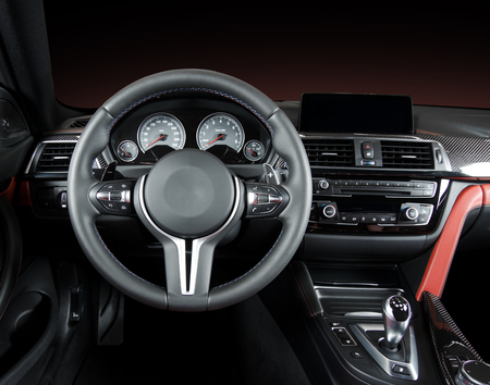 Modern luxury car Interior - steering wheel, shift lever and dashboard. Car interior luxury.Steering wheel, dashboard, speedometer, display. Red and black perforated leather.の写真素材