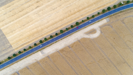 Aerial view of a country road with cars between agricultural fields in Europe, Germany. Beautiful...