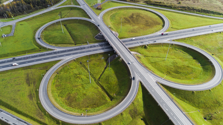 Aerial view of highway interchange  Road junction Aerial photo of a highway going through the forest