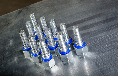 Metal hydraulic fittings stands on the silver table in the warehouseの写真素材