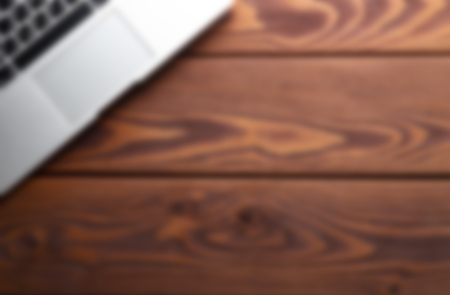 Abstract blurred background image of wooden workplace with laptopの写真素材