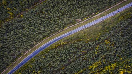 Aerial view of a car on the road. Autumn landscape countryside. Aerial photography of autumn forest with a car on the road. Captured from above with a drone. Aerial photo. Quadcopter. Aerial car view.の写真素材