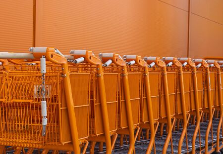 Orange shopping cart stacked by the entrance for new customers to use outside the store orange wallの写真素材
