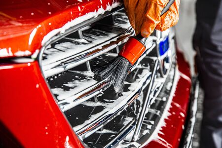 Sankt-Petersburg, Russia - April 23 2017: Close-up of a volvo cars manufacturing logo on the modern car while washing in the detaing workshop with foam soap and worker hand with a brushのeditorial素材