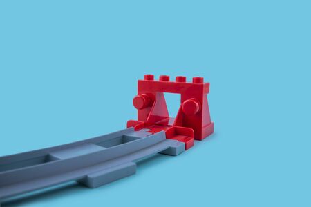 End of the plastic toy railway on the blue background concept