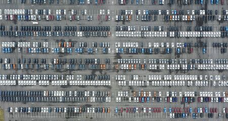 Rows of new cars in the parking lot. Aerial view of large parking lot full of cars of various colorsの写真素材