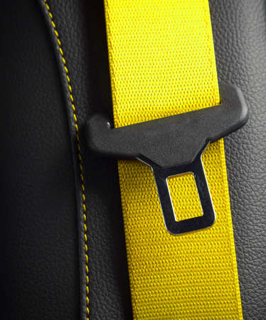 Modern race car black leather interior. Part of yellow leather car seat details. Safety belt close-upの写真素材