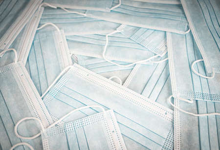 Close-up disposable medical masks in the stack detailed macro photo. Medical mask texture.