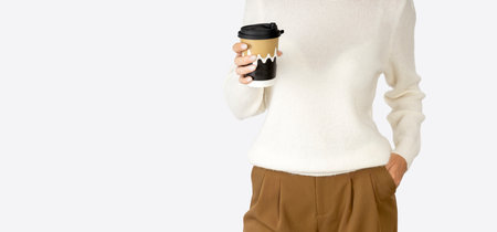 Pretty young woman with a cup of fresh coffee to go cup in her hands studio shot on light background