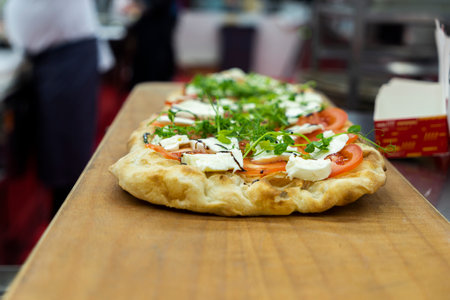Food concept. Preparing traditional italian pizza. ready dish with green rucola herbs in interior of...