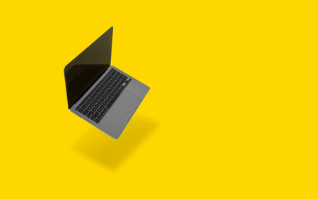 Photo of realistic modern laptop floating in front of a yellow backgroundの写真素材