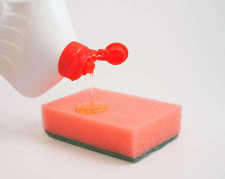 The washing-up liquid flows on a kitchen sponge from a bottle a squirt    の写真素材
