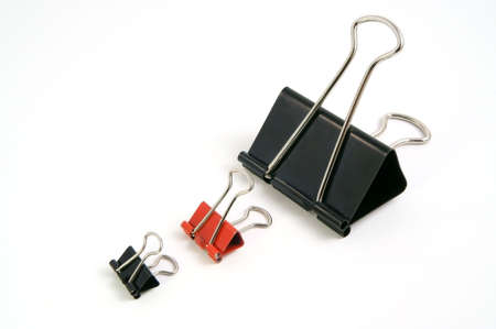 Three clips for a paper of the different sizes and colors on a white background             の写真素材