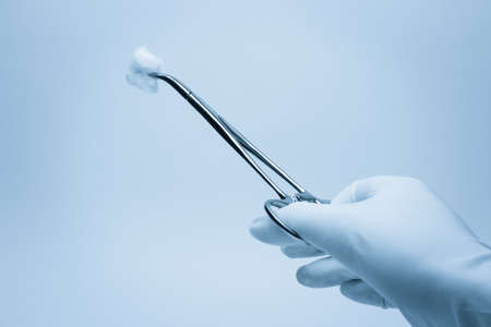 hand of surgeon with forceps during surgeryの写真素材