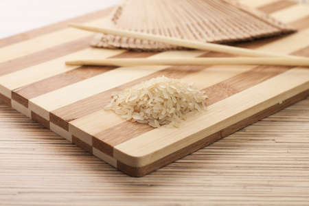 raw rice ready to be cooked on the breadboardの写真素材