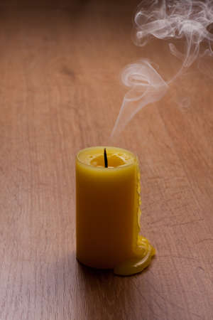 went out candle on wooden table with lots of smokeの写真素材
