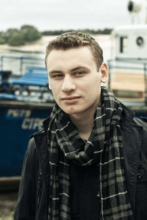 portrait of man standing on the river bank with ship as backgroundの写真素材
