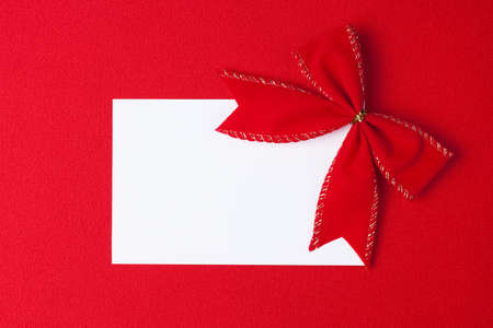 blank card with bow over red backgroundの写真素材