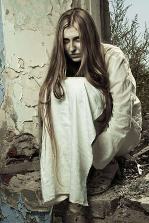 zombie girl sitting in abandoned building