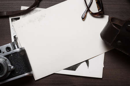 retro still camera and some old photos on wooden table backgroundの写真素材