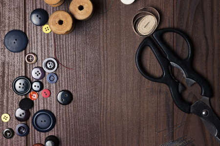 threads buttons and needles on brown wooden tableの写真素材