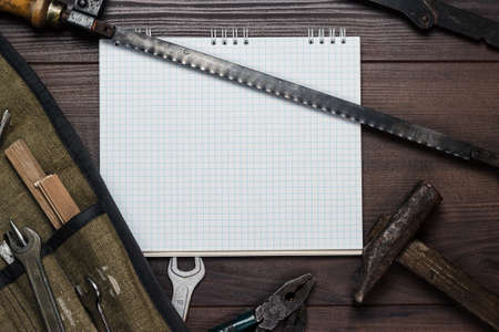 construction tools and blank notepad on the wooden backgroundの写真素材