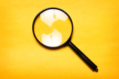 magnifying glass on yellow backgroundの写真素材