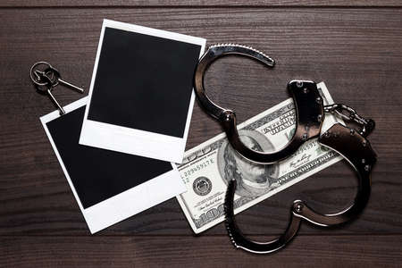 handcuffs money and old photos detective conceptの写真素材