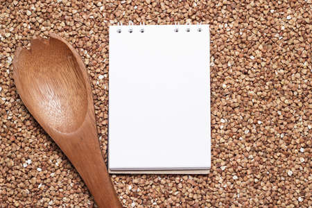 buckwheat with brown wooden spoon and notepad food preparationの写真素材