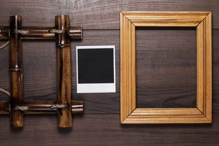 empty frames and old photo on the wooden table backgroundの写真素材