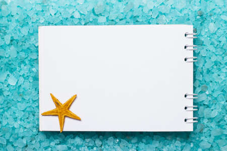 notepad and starfish on blue bath salt backgroundの写真素材